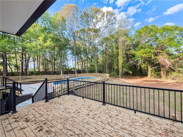 view of patio featuring a jacuzzi, a fenced backyard, a fenced in pool, and a deck