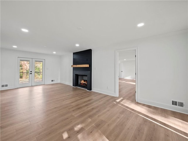 unfurnished living room featuring light wood-type flooring, baseboards, a large fireplace, recessed lighting, and visible vents