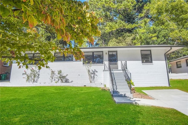 ranch-style home featuring brick siding and a front lawn