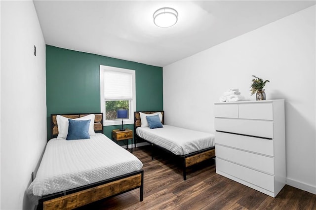 bedroom with baseboards and dark wood-style floors