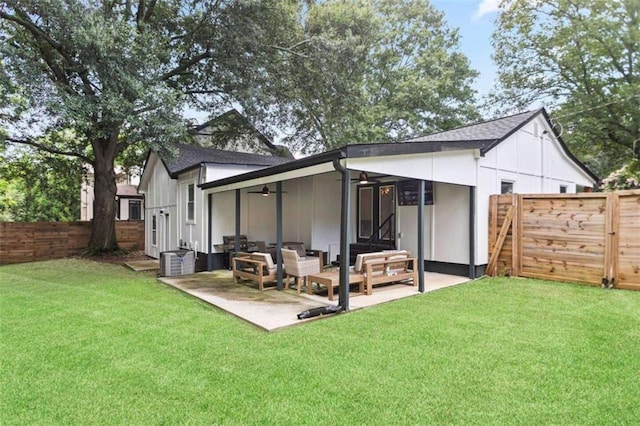 rear view of property featuring a patio, fence, central AC, and a lawn