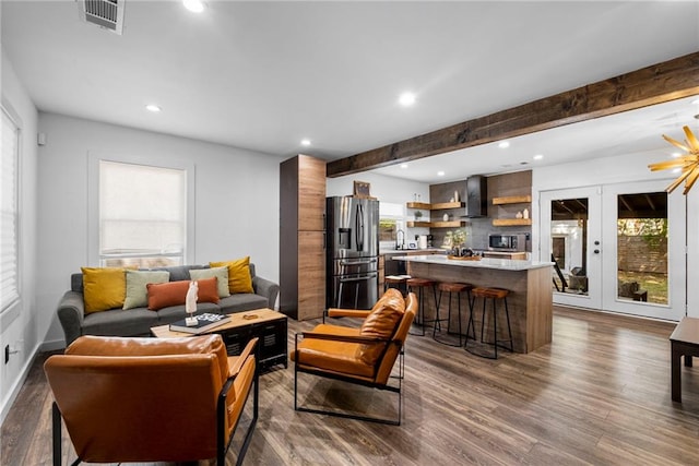 living area with a wealth of natural light, recessed lighting, visible vents, and dark wood-style flooring