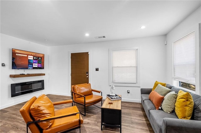 living room featuring visible vents, baseboards, and wood finished floors