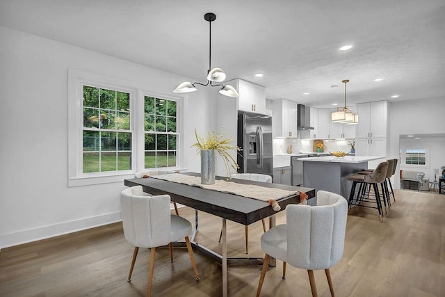 dining space featuring baseboards, light wood-type flooring, a wealth of natural light, and recessed lighting