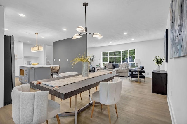 dining space featuring baseboards, recessed lighting, light wood-type flooring, and stairs
