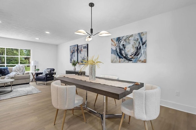 dining area featuring wood finished floors, recessed lighting, a notable chandelier, and baseboards