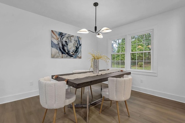 dining room featuring a chandelier, baseboards, and wood finished floors