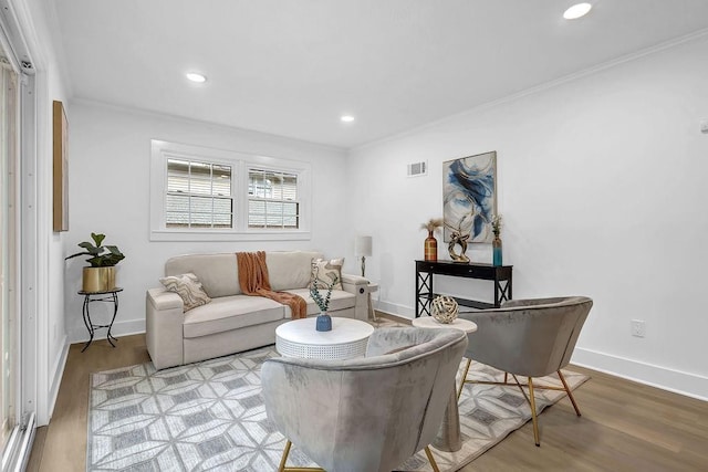 living area with visible vents, wood finished floors, crown molding, and recessed lighting