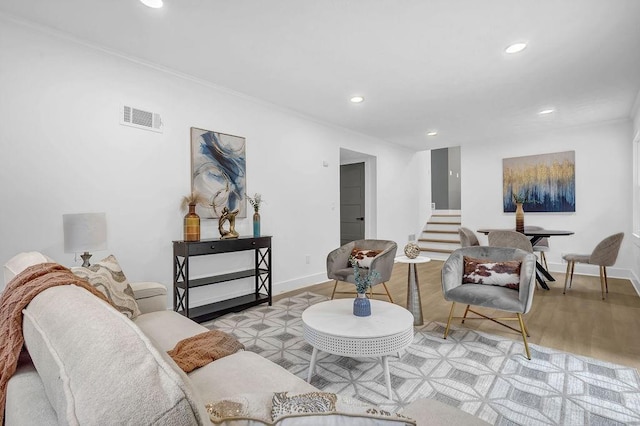 living area featuring wood finished floors, visible vents, recessed lighting, and stairs