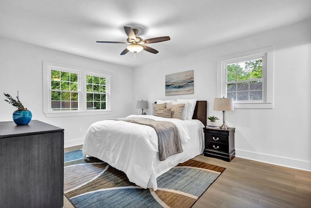 bedroom with wood finished floors, ceiling fan, and baseboards