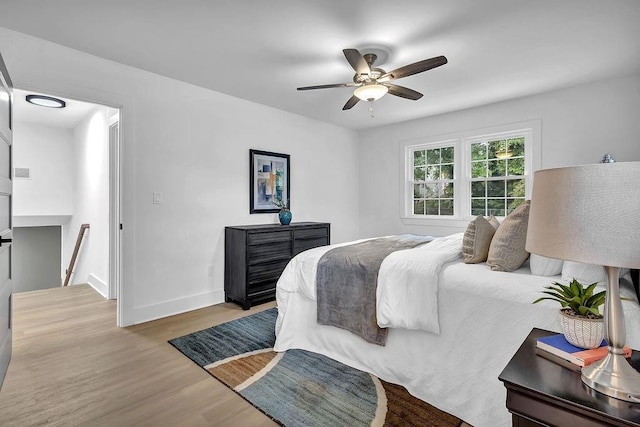 bedroom featuring wood finished floors, ceiling fan, and baseboards