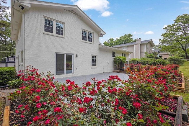 back of house featuring fence, a patio, and brick siding