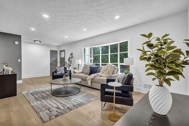 living room featuring recessed lighting, wood finished floors, and baseboards
