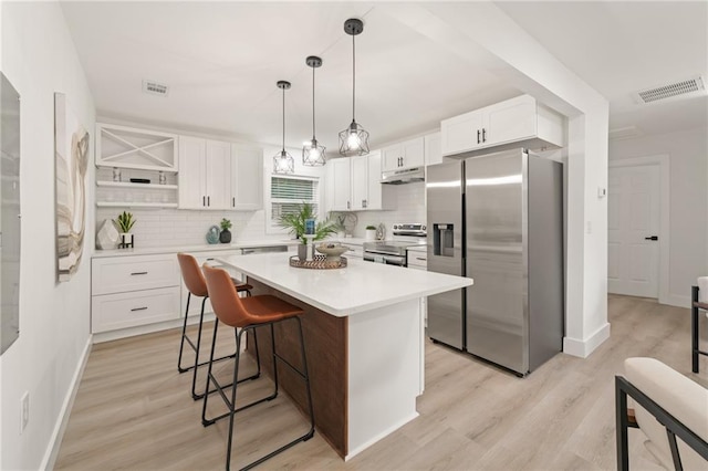 kitchen with tasteful backsplash, stainless steel appliances, a center island, and white cabinets