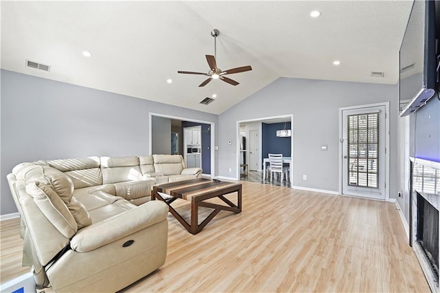 living area with vaulted ceiling, baseboards, visible vents, and light wood-style floors