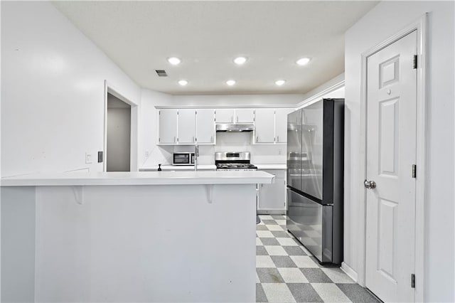 kitchen with light countertops, appliances with stainless steel finishes, light floors, and white cabinetry