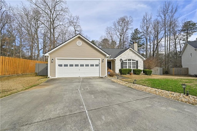 ranch-style house featuring driveway, a garage, a chimney, fence, and a front yard