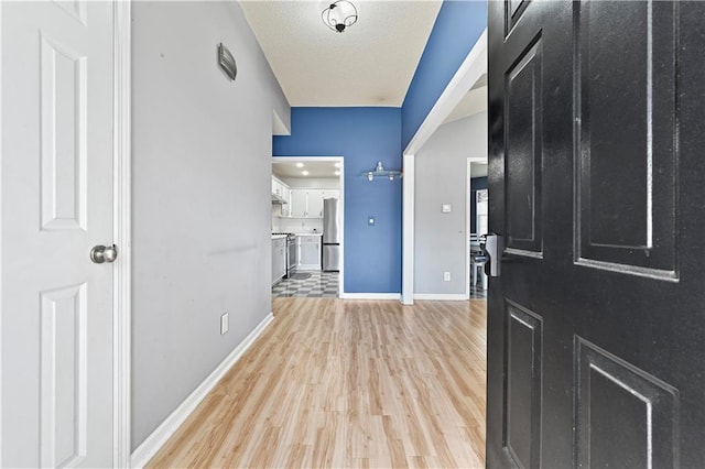 entrance foyer featuring light wood finished floors and baseboards