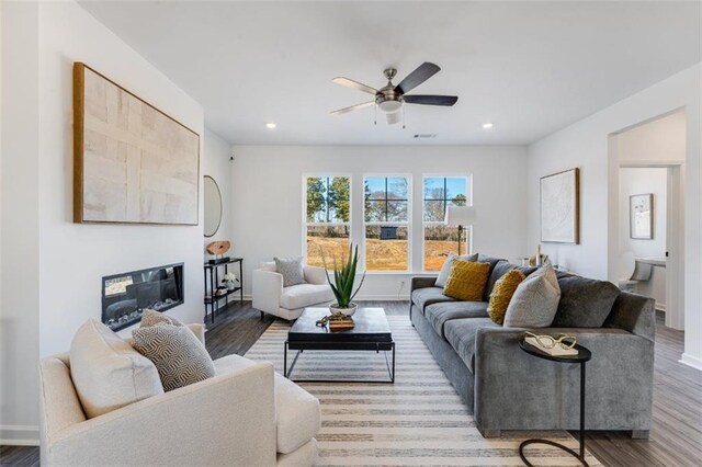 6121 Wayburn St, Tucker, GA 30084 - living area featuring wood finished floors, a ceiling fan, a glass covered fireplace, and recessed lighting