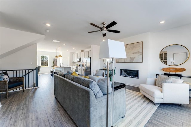 6121 Wayburn St, Tucker, GA 30084 - living room featuring a ceiling fan, wood finished floors, recessed lighting, and a glass covered fireplace