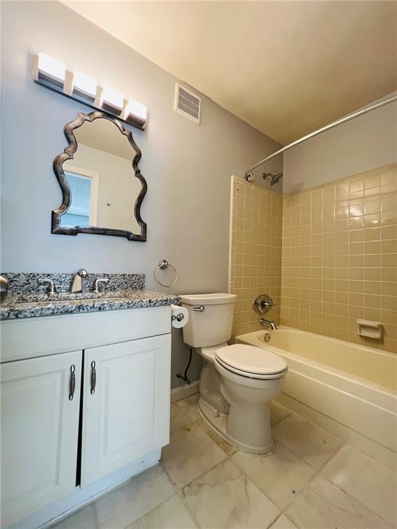 full bath with visible vents, marble finish floor, toilet, vanity, and  shower combination