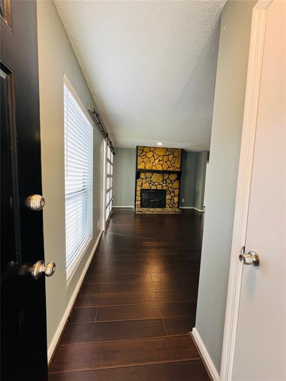interior space featuring baseboards, wood finished floors, and a textured ceiling