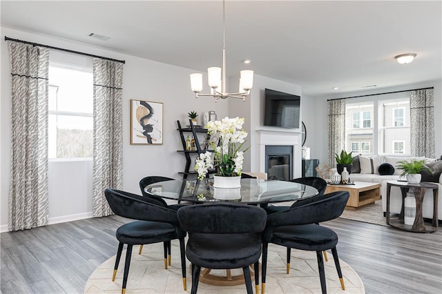 528 Aberdeen Mdw, Acworth, GA 30102 - dining space with light wood-type flooring, a glass covered fireplace, visible vents, recessed lighting, and a chandelier