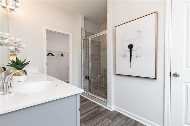 528 Aberdeen Mdw, Acworth, GA 30102 - bathroom with a shower stall, wood finished floors, a sink, a walk in closet, and double vanity