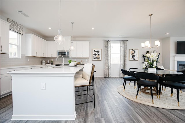 528 Aberdeen Mdw, Acworth, GA 30102 - kitchen featuring visible vents, stainless steel microwave, a wealth of natural light, and a notable chandelier