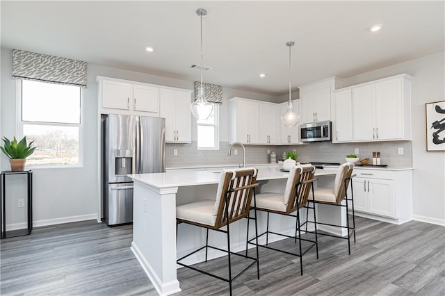 528 Aberdeen Mdw, Acworth, GA 30102 - kitchen featuring light wood-style flooring, appliances with stainless steel finishes, light countertops, and a kitchen island