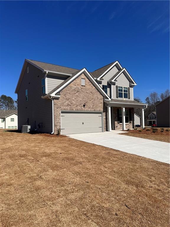 view of front of property with a garage, driveway, a front lawn, and central AC unit