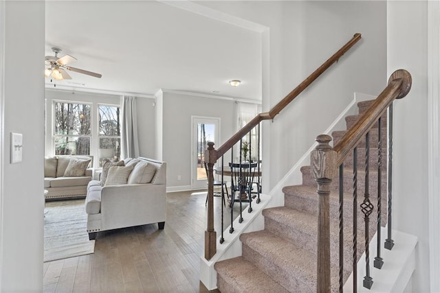 interior space with stairway, ornamental molding, ceiling fan, wood finished floors, and baseboards