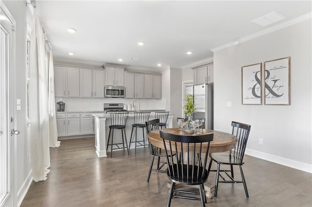 dining area featuring recessed lighting, visible vents, baseboards, ornamental molding, and dark wood finished floors