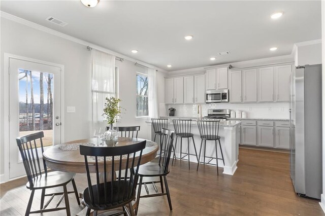 dining space with dark wood finished floors, visible vents, crown molding, and recessed lighting