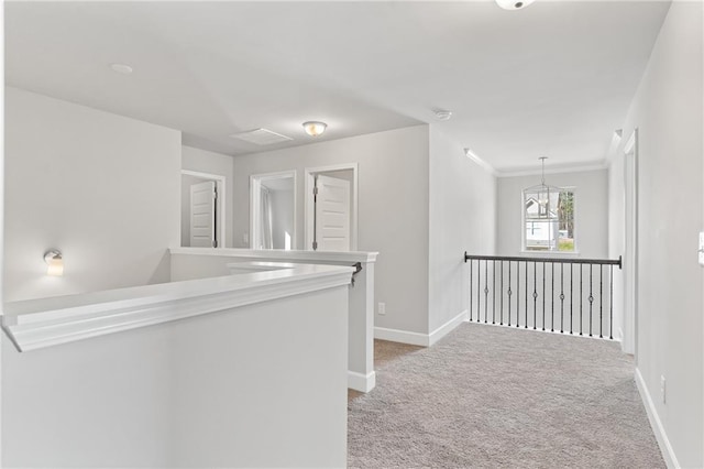 hallway featuring light carpet, baseboards, ornamental molding, and an upstairs landing