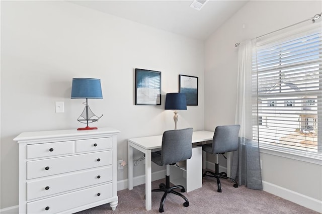 office space featuring light carpet, vaulted ceiling, visible vents, and baseboards