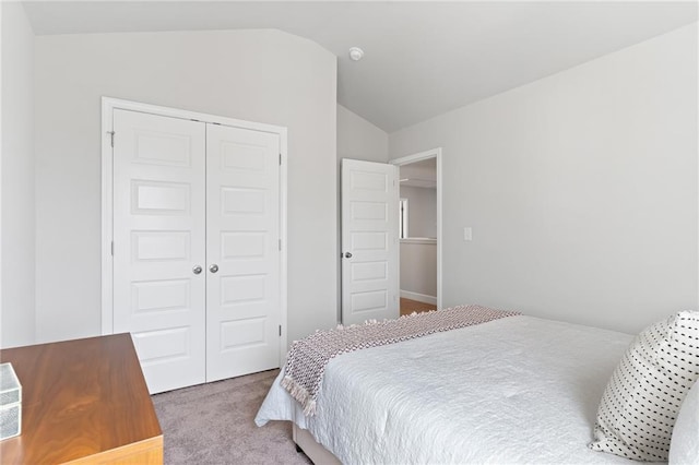 carpeted bedroom featuring lofted ceiling and a closet