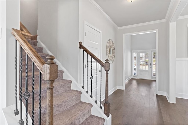 foyer with dark wood-style floors, crown molding, baseboards, and stairs