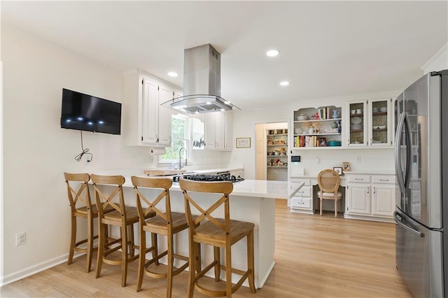 4086 Norton Pl SE, Smyrna, GA 30082 - kitchen with white cabinets, built in study area, island exhaust hood, and freestanding refrigerator