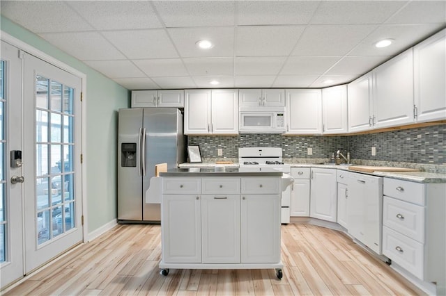 4086 Norton Pl SE, Smyrna, GA 30082 - kitchen featuring white appliances, light wood-style flooring, white cabinetry, and a kitchen island