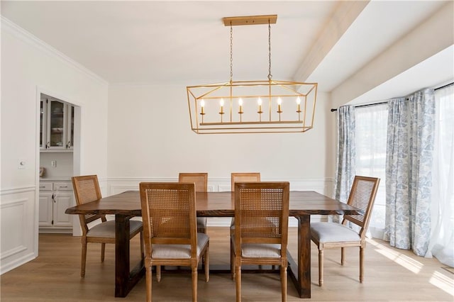 4086 Norton Pl SE, Smyrna, GA 30082 - dining space featuring a notable chandelier, light wood-type flooring, crown molding, a wainscoted wall, and a decorative wall