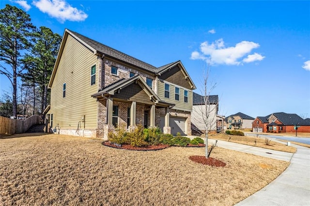 craftsman-style house with brick siding, an attached garage, driveway, and fence