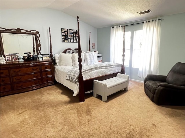 bedroom with a textured ceiling, lofted ceiling, and light carpet