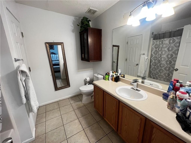 bathroom with toilet, a textured ceiling, vanity, and tile patterned floors