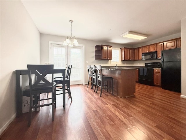 602 Summer Pl, Norcross, GA 30071 - kitchen with black appliances, a chandelier, dark countertops, open shelves, and dark wood-type flooring