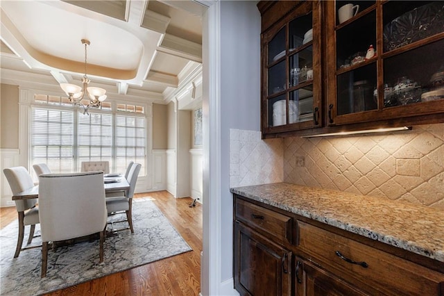 652 Pathview Ct, Dacula, GA 30019 - dining room featuring a chandelier, coffered ceiling, light wood-style floors, a decorative wall, and wainscoting
