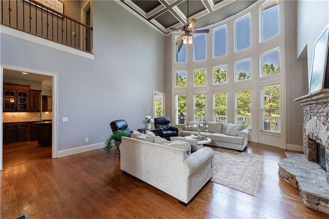 652 Pathview Ct, Dacula, GA 30019 - living area featuring a towering ceiling, coffered ceiling, baseboards, ceiling fan, and a fireplace