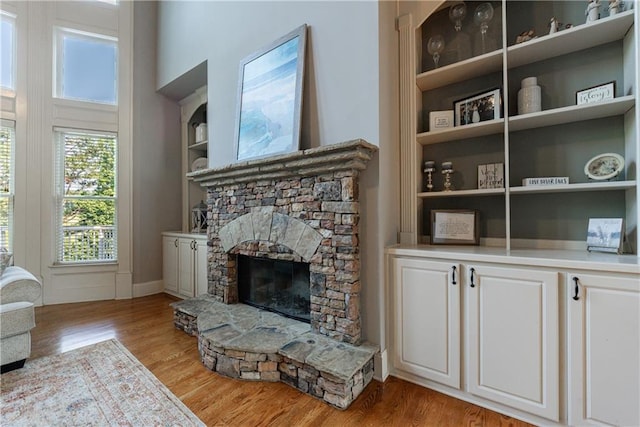 652 Pathview Ct, Dacula, GA 30019 - living area with light wood finished floors, a stone fireplace, baseboards, and built in features