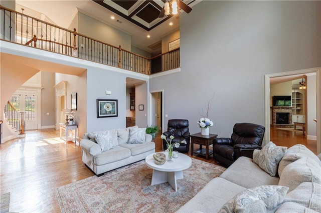 652 Pathview Ct, Dacula, GA 30019 - living area with a ceiling fan, stairs, a towering ceiling, a fireplace with raised hearth, and arched walkways