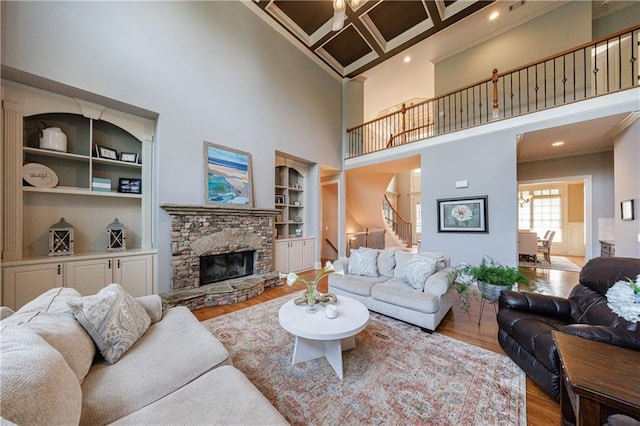 652 Pathview Ct, Dacula, GA 30019 - living area featuring a towering ceiling, wood finished floors, stairs, crown molding, and a fireplace